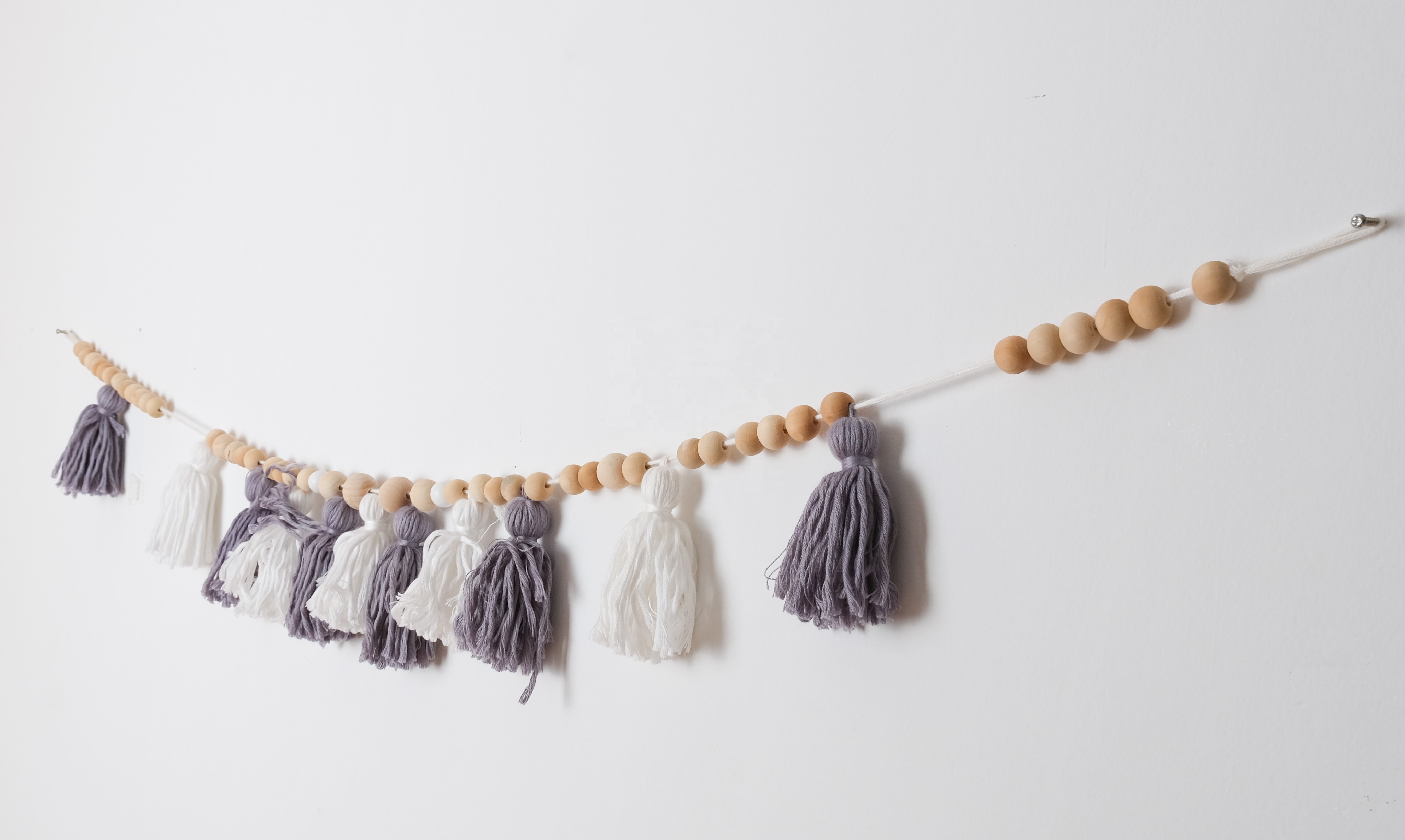 purple and white tassle beaded bunting wall decor